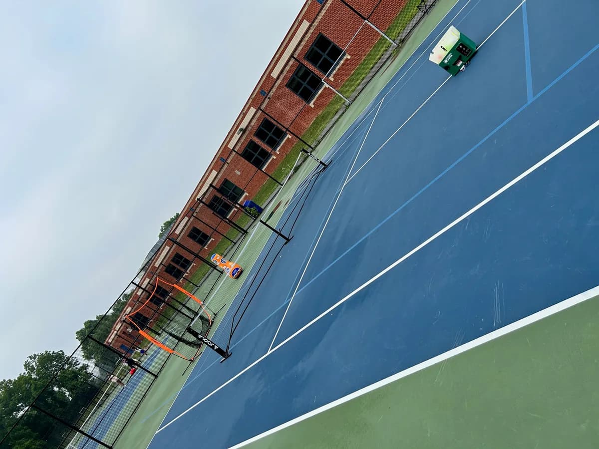 Outdoor pickleball courts with nets and trees nearby